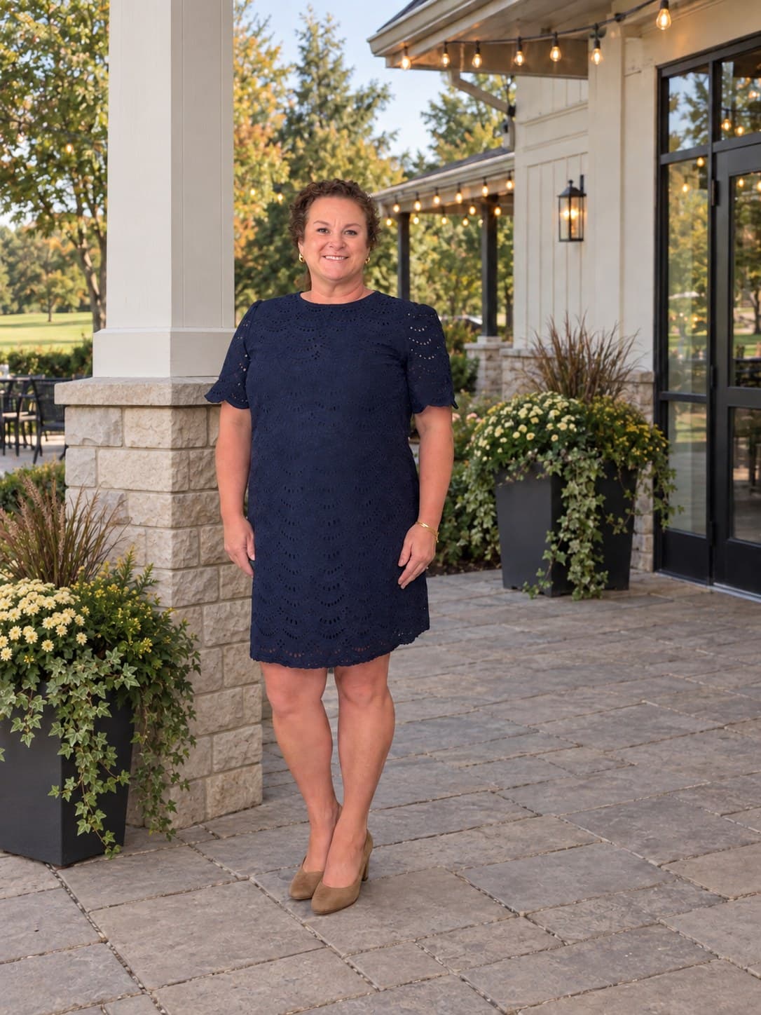 Erin on a patio in a navy dress