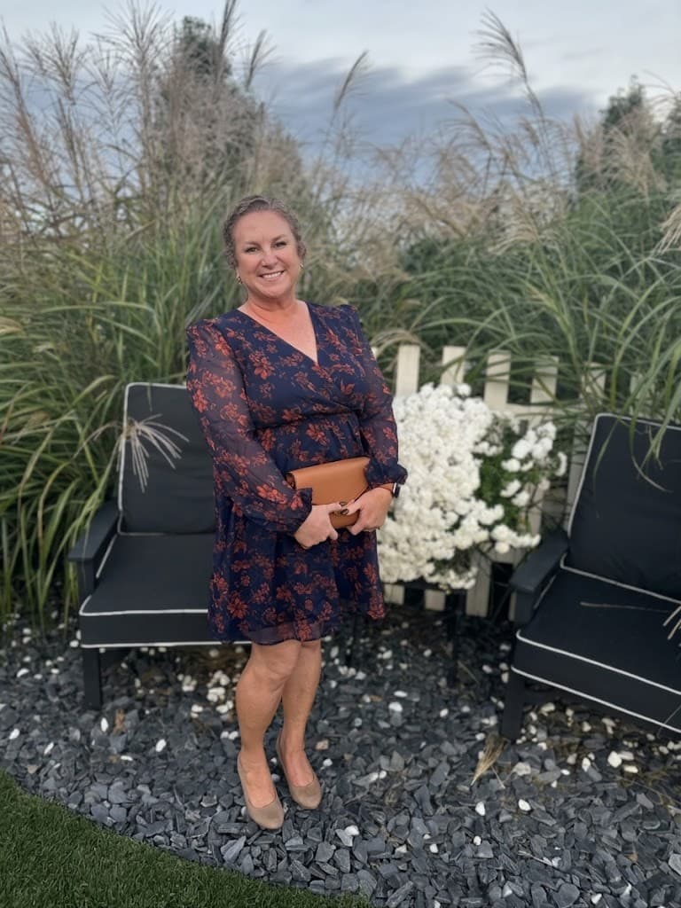 Erin in a navy floral dress in the garden