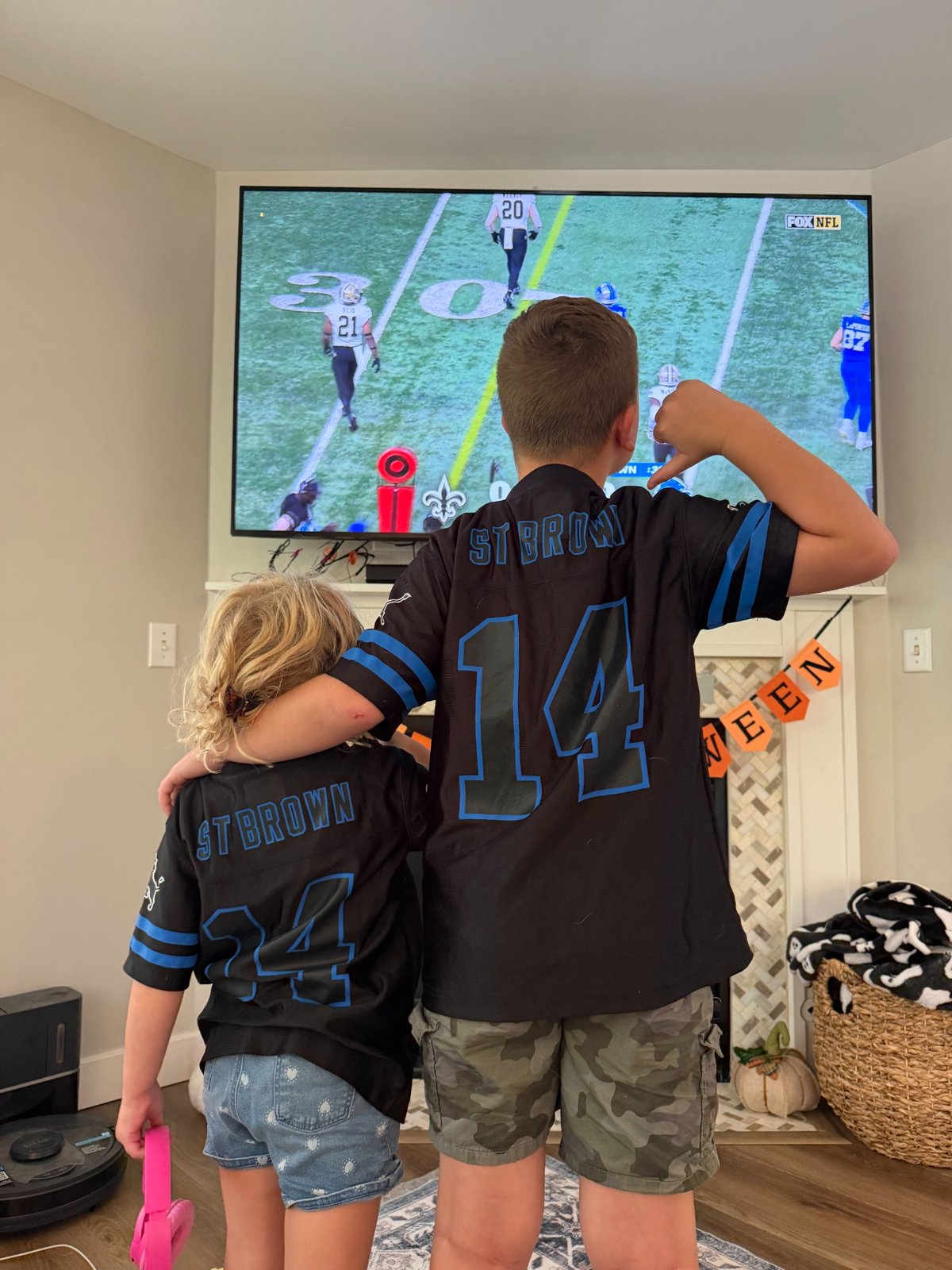 The kids in their Lions jerseys watching the game